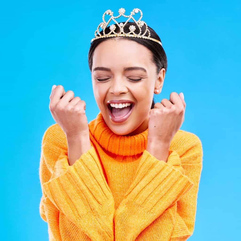 Winner, crown and portrait of woman in studio for celebration, princess and party. Smile, beauty an